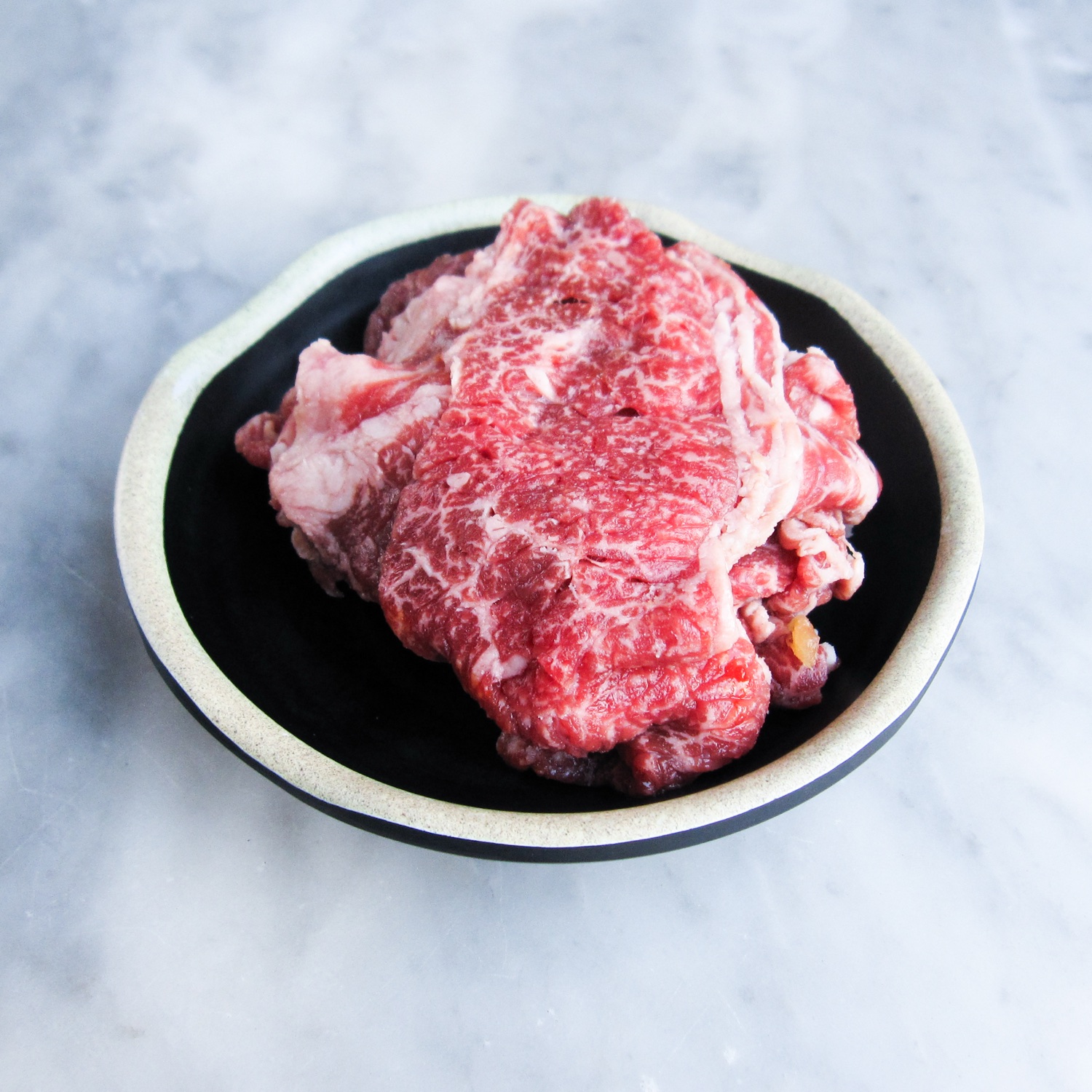 Marinated beef in a bowl before grilling