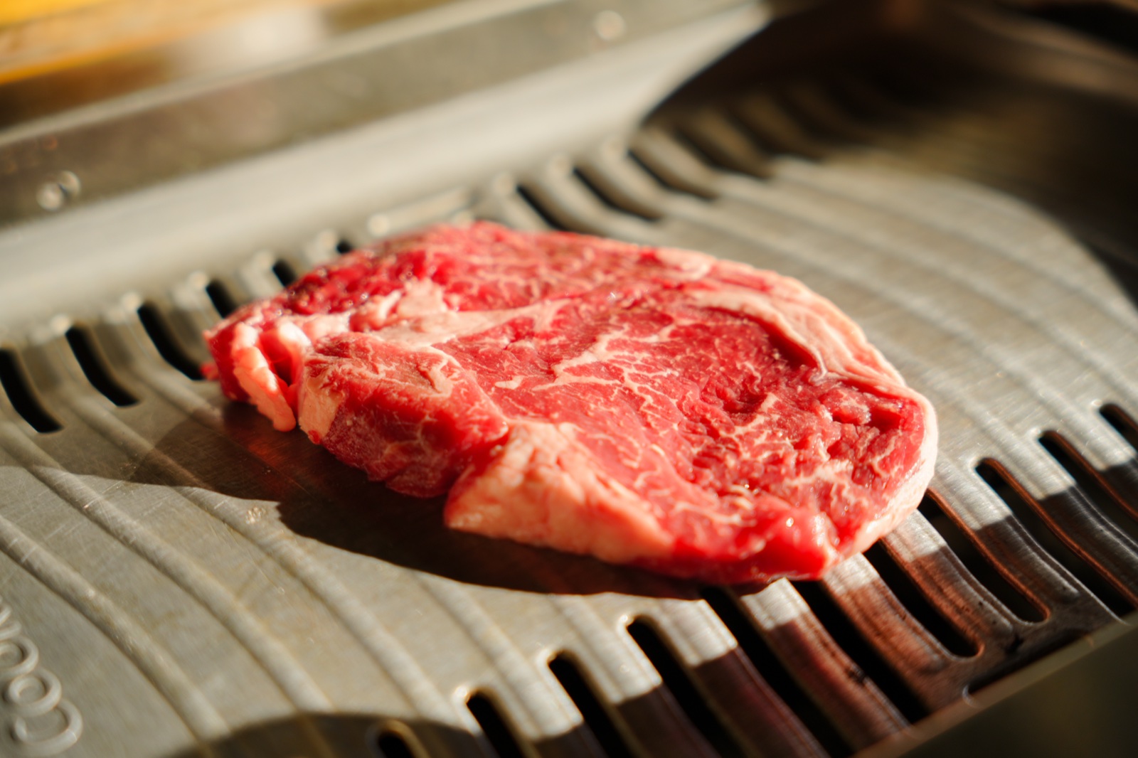 Fresh marbled beef on the table grill at Mrs Kim's Grill
